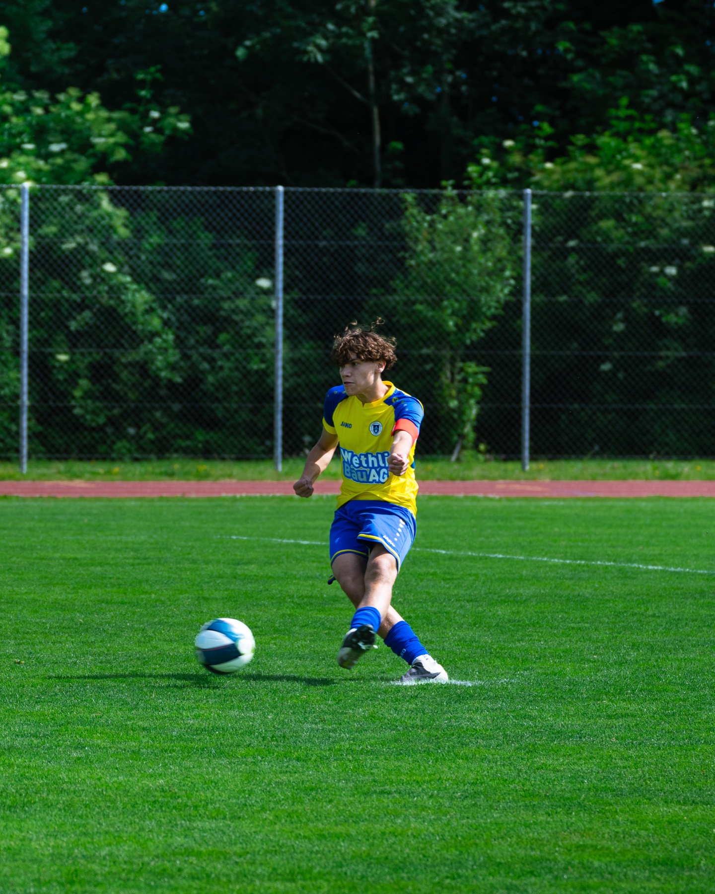 Spieler im gelb-blauen Trikot beim Pass, FC Hinwil