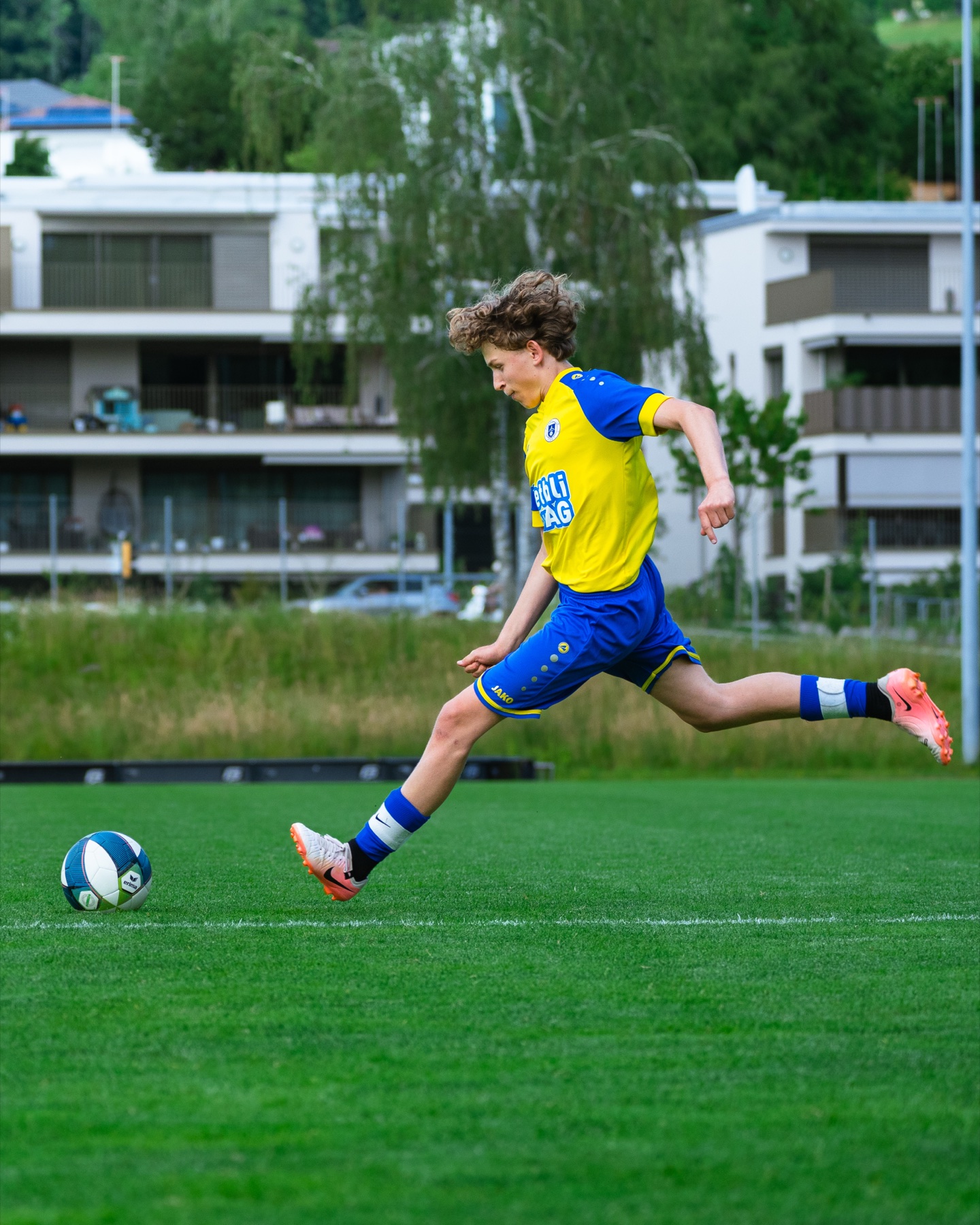 Spieler holt zum Weitschuss aus, Sportplatz Hinwil