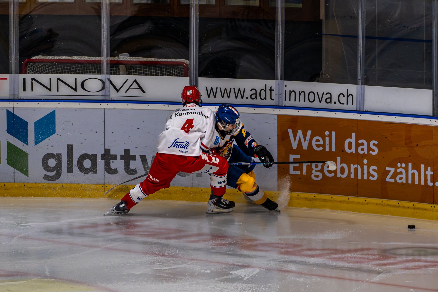 Zweikampf um den Puck an der Bande, Kunsteisbahn Dübendorf