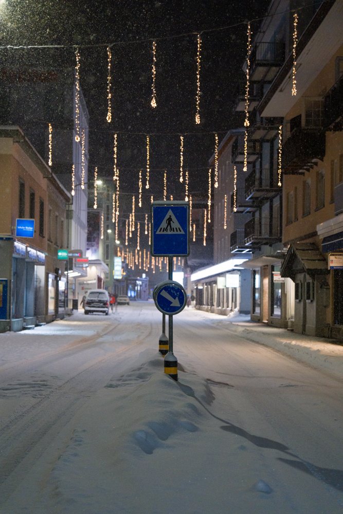 Lichterketten über einer verschneiten Strasse in Davos