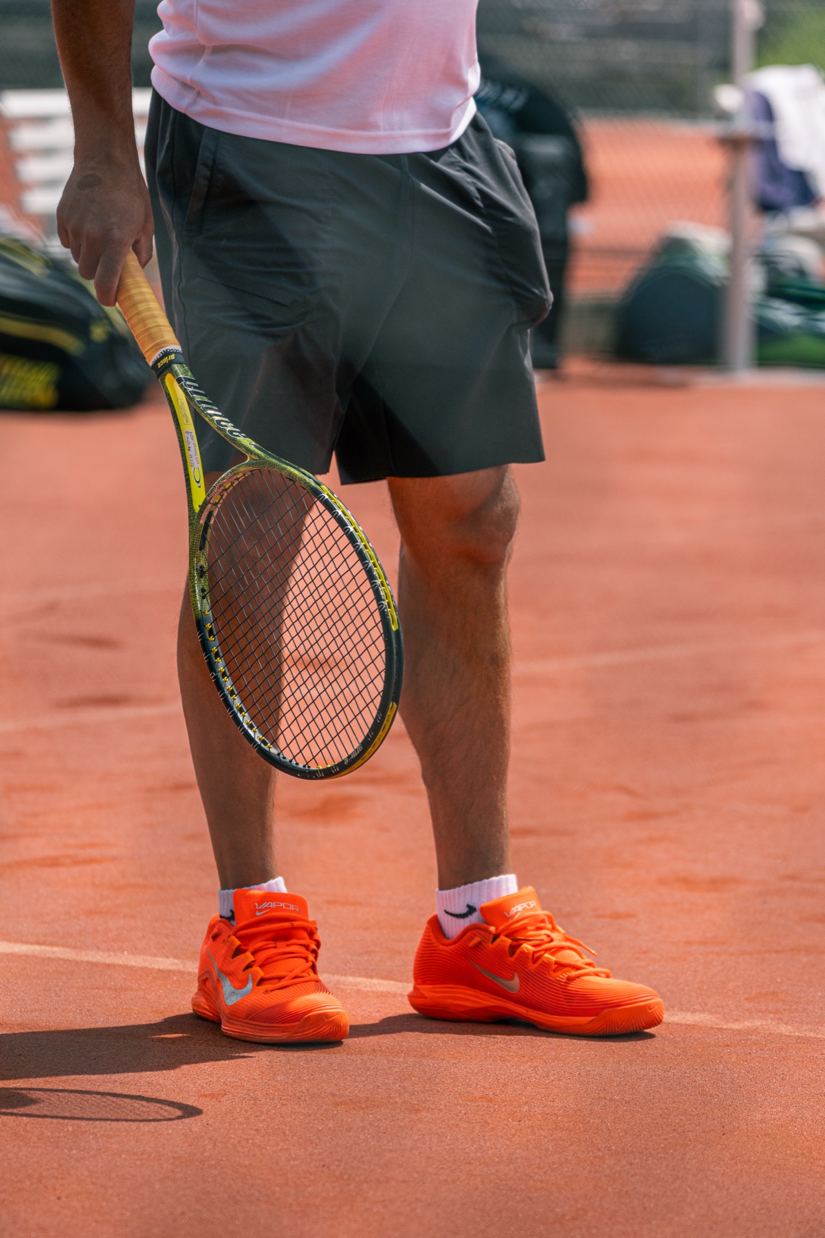 Tennisschläger und orange Schuhe auf dem Sandplatz, TC Hinwil